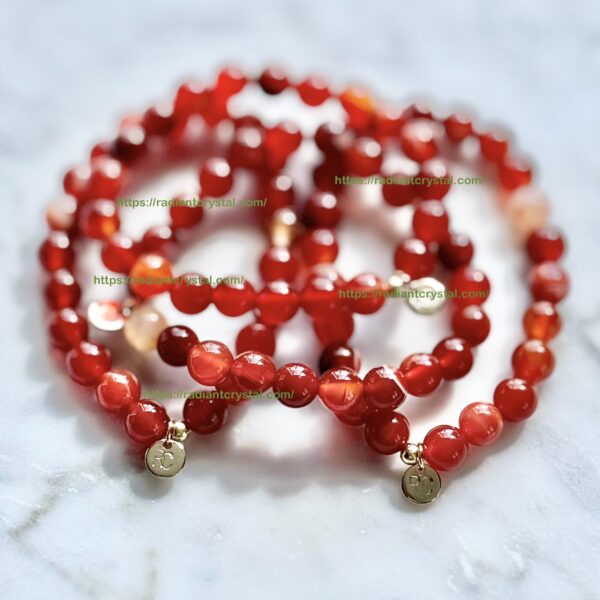 Red carnelian bead bracelets with gold charms.