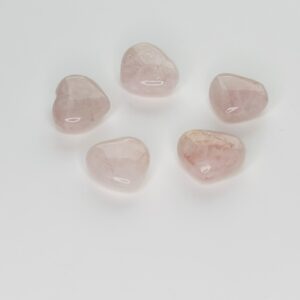 A group of five pink stones sitting on top of a white surface.