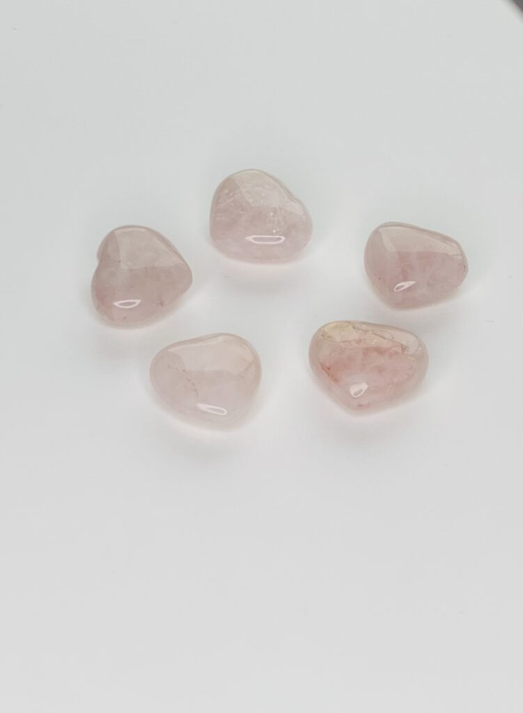 A group of five pink stones sitting on top of a white surface.