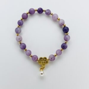 A purple bracelet with gold beads and a white bead.