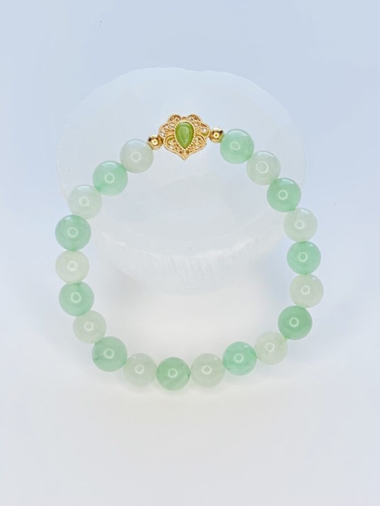 A green and white bracelet is sitting on top of a table.