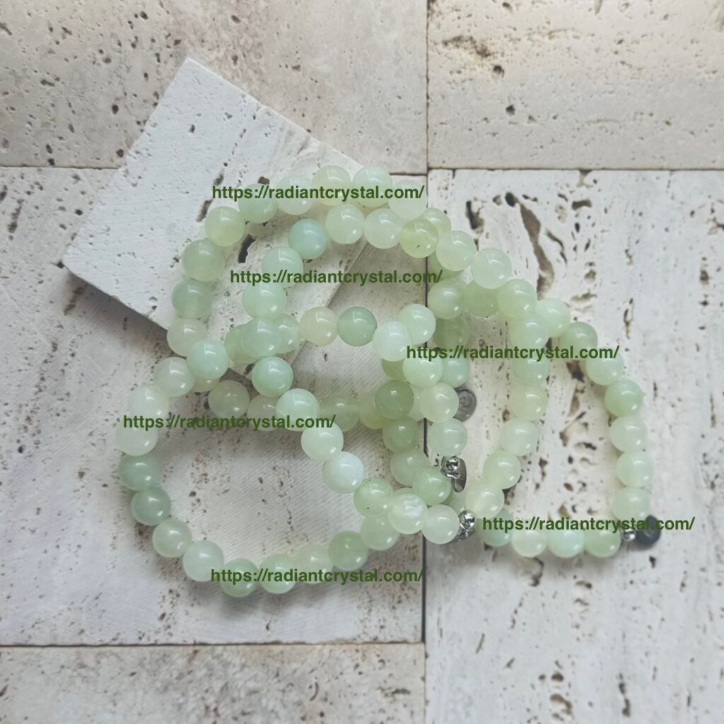 Green jade bead bracelets on textured surface.