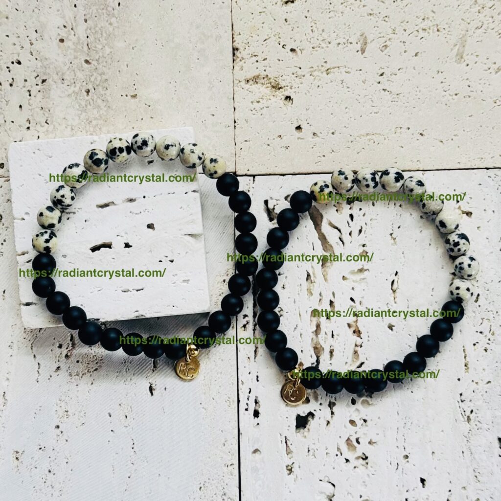 Dalmatian and black beaded bracelets on stone.