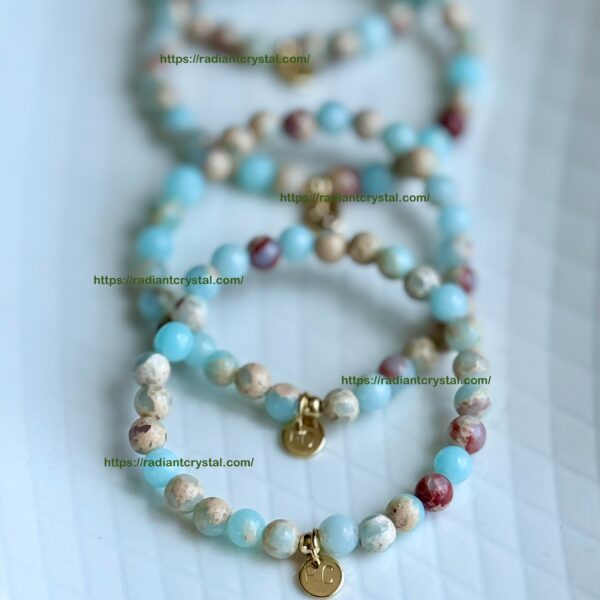 Four beaded bracelets with gold charms.