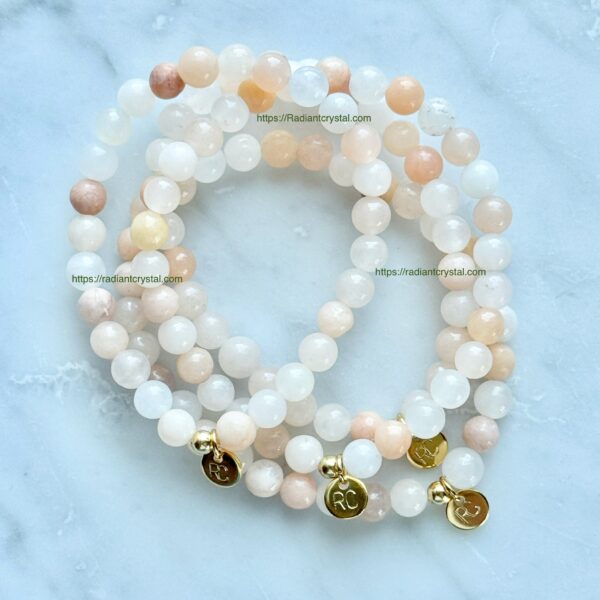 Three beaded bracelets with gold charms.