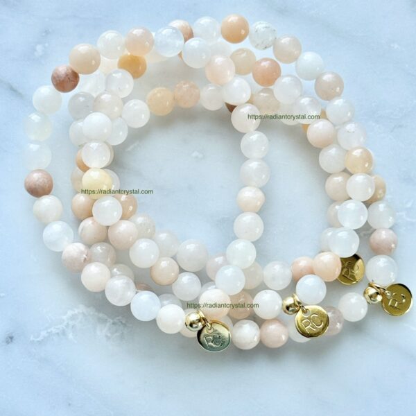 Three beaded bracelets with gold charms.