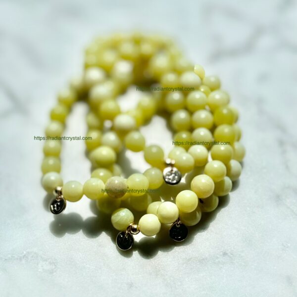 Green jade beaded bracelet with gold charms.