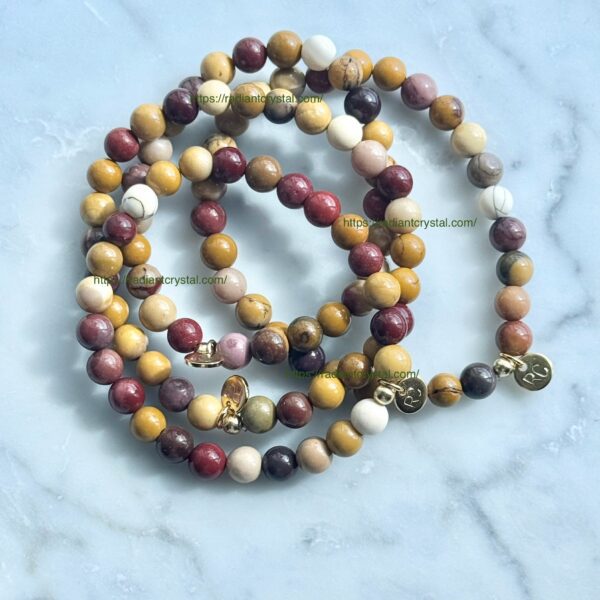 Multicolored stone bead bracelets with gold charms.