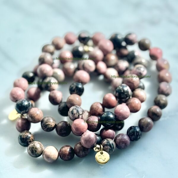 Pink and black beaded bracelets with gold charms.