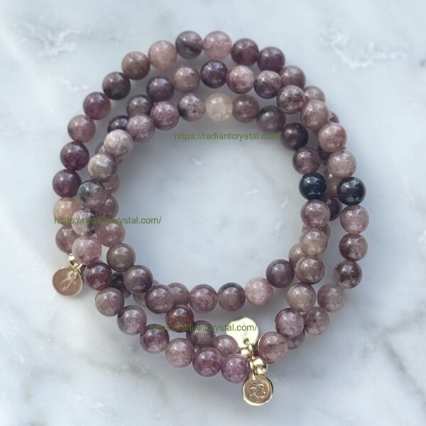 Purple and black gemstone bracelet with gold charms.