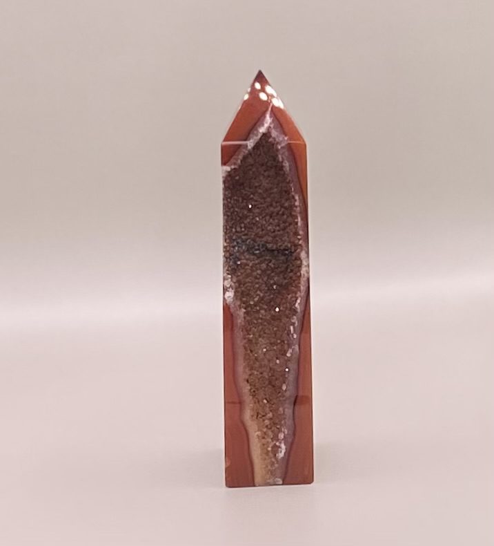 A Carnelian Druzy Tower-A on a white surface.