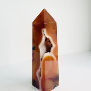 A Carnelian Druzy Tower-A sitting on top of a white surface.