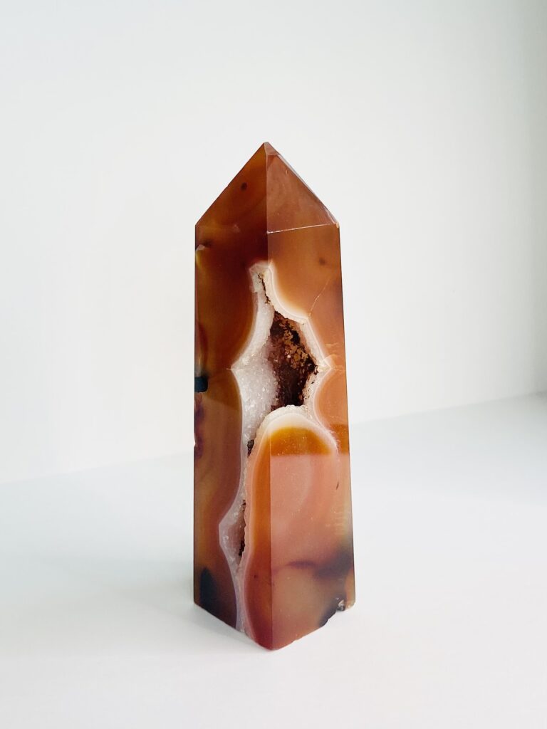 A Carnelian Druzy Tower-A sitting on top of a white surface.