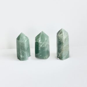 Three green jade points on a white surface.