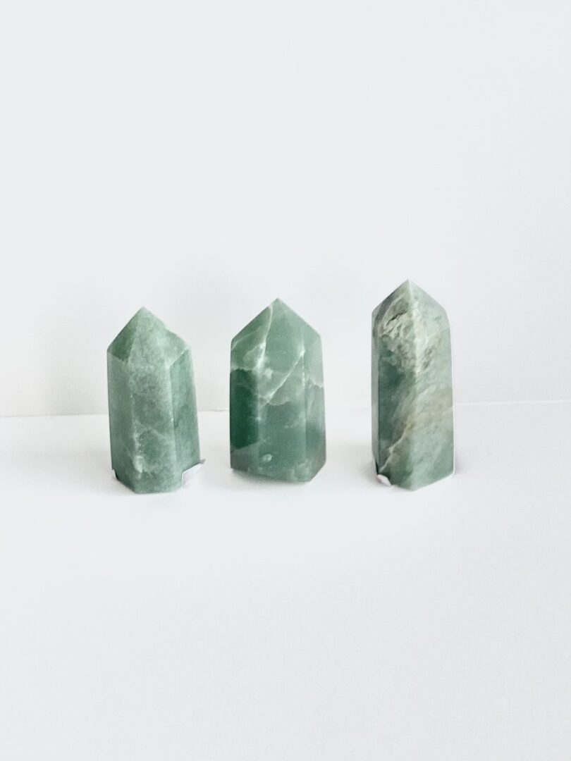 Three green jade points on a white surface.