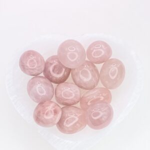 A heart shaped bowl filled with Rose Quartz Tumbled Stones.