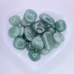 Green aventurine tumbled stones in a heart shaped bowl.