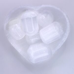 A heart shaped bowl filled with Selenite - Cylinder crystals.