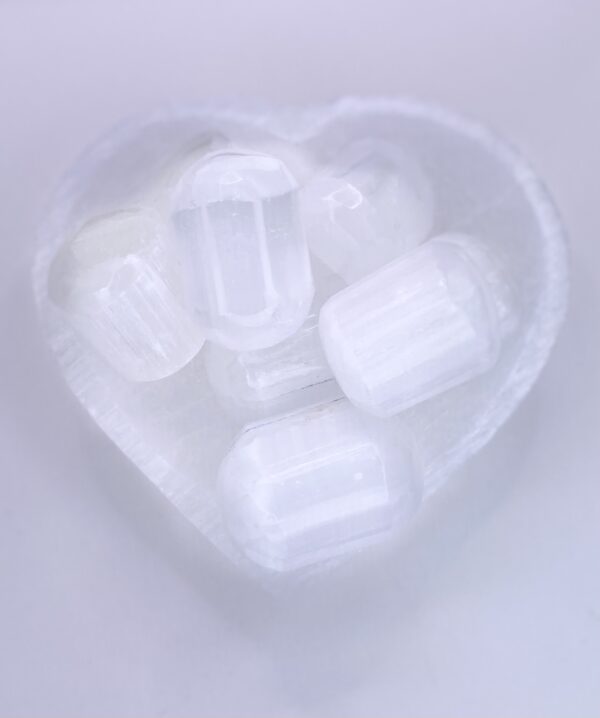 A heart shaped bowl filled with Selenite - Cylinder crystals.