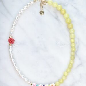 A Dream Amethyst Necklace with yellow beads and a heart charm.
