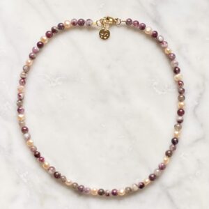 A Plum Blossom Tourmaline & Pearls necklace on a marble table.