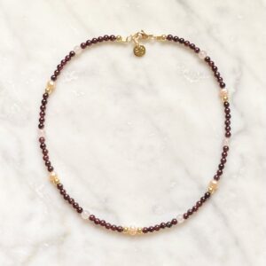 An Intimacy Necklace on a marble table.