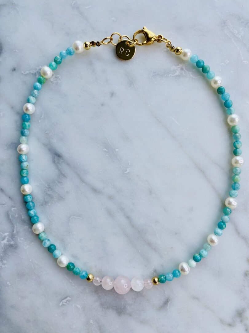 An Amazonite-Rose Quartz & Pearls Choker on a marble table.