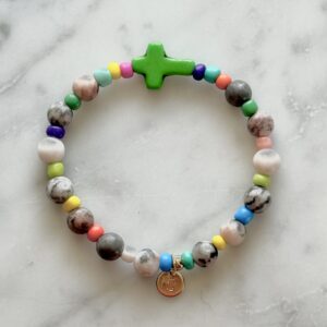 Colorful beaded bracelet with a green cross charm.