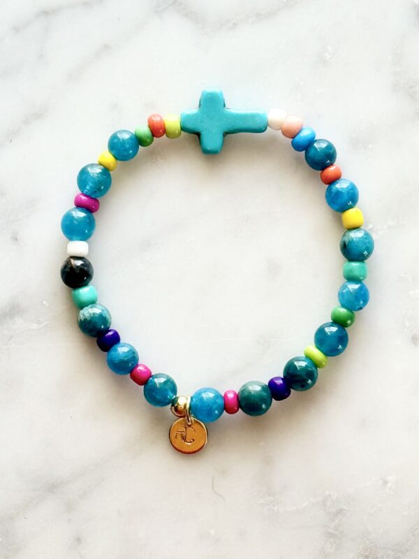 Beaded bracelet with a turquoise cross charm.