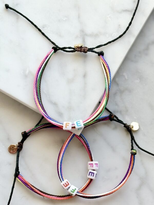 Three colorful bracelets spelling "FEE"