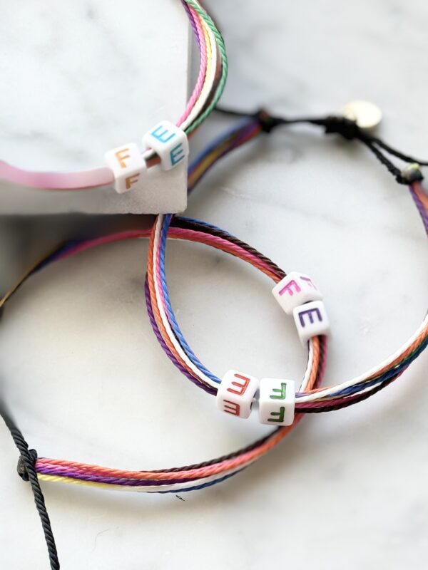 Two rainbow friendship bracelets with "FE" beads.