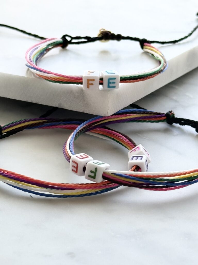 Rainbow string bracelets with letter beads.