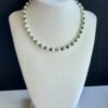White pearl and green stone necklace.