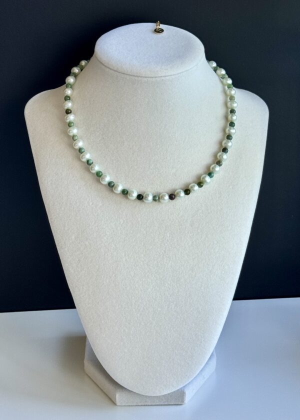 White pearl and green stone necklace.