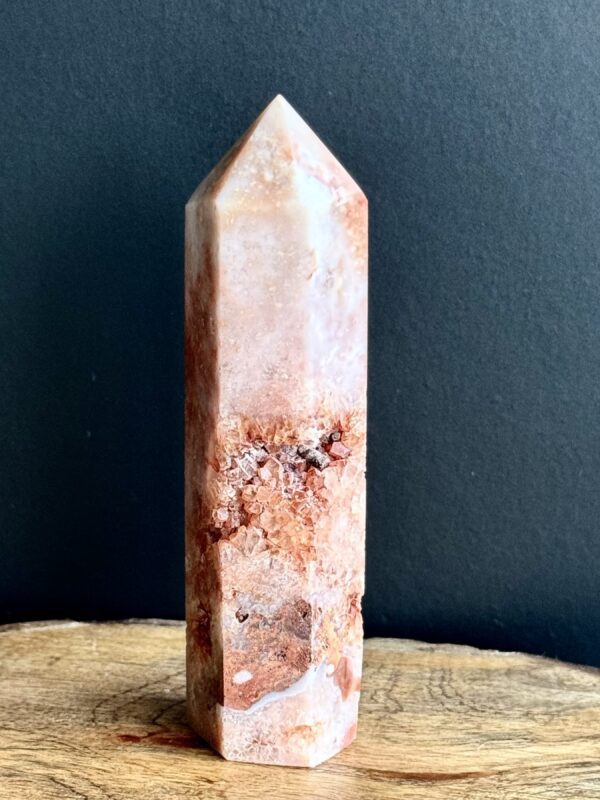 Orange and white crystal point on wood.