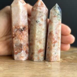 Three sunstone crystal points on wood.