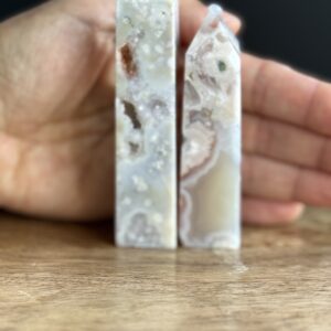 Two white agate crystal points on wood.