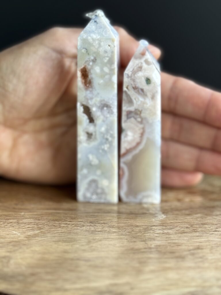 Two white agate crystal points on wood.