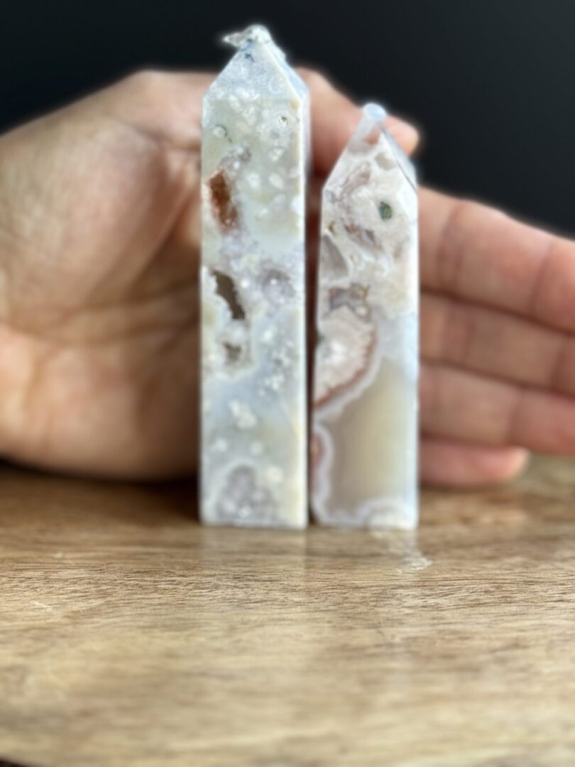 Two white agate crystal points on wood.