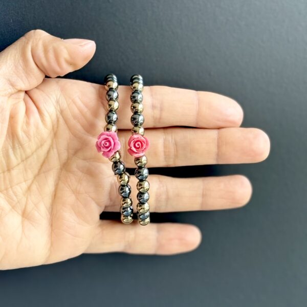 Two beaded bracelets with pink rose charms.