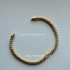 Gold bead bracelet on white background.