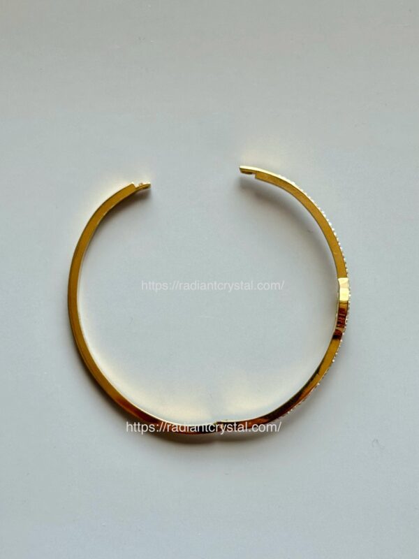 Gold bangle with sparkling stones.