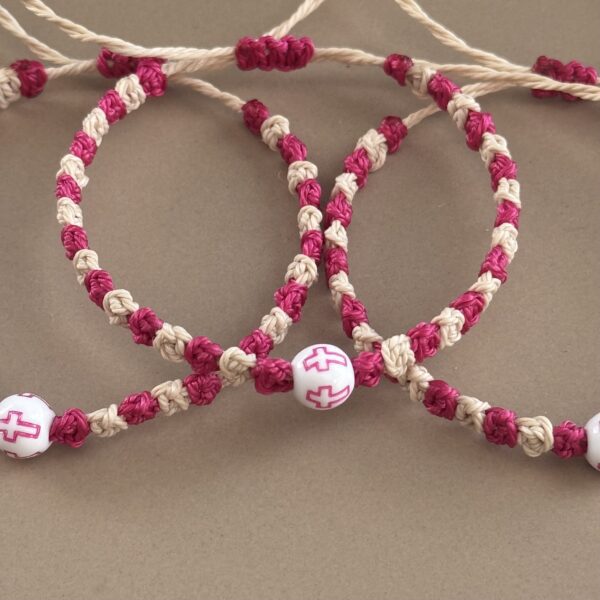 Two pink and white cross bracelets.