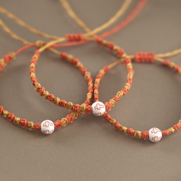 Three braided bracelets with cross beads.