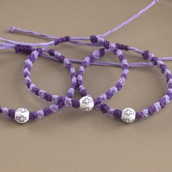 Three purple prayer bracelets with crosses.