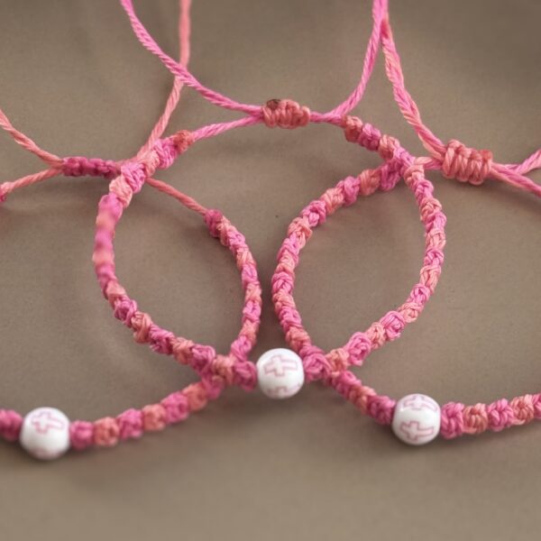 Three pink bracelets with cross beads.