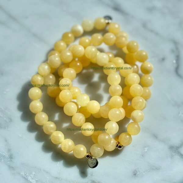 Three yellow gemstone bracelets on marble.