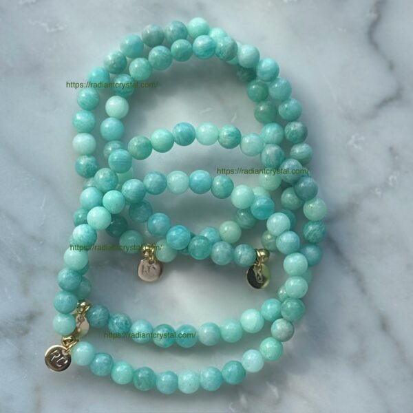 Green gemstone bead bracelets with gold charms.