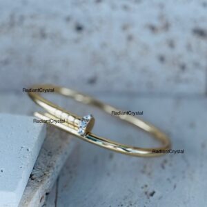 Gold nail bangle with clear stones.