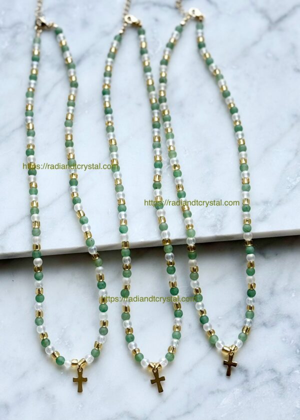 Three green and gold beaded necklaces with cross charms.